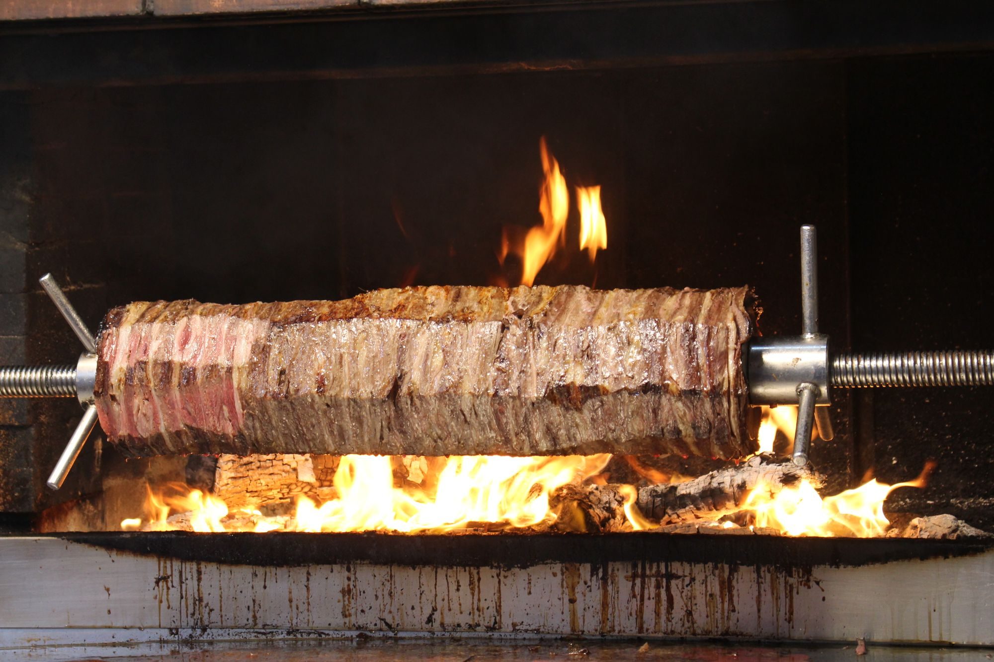 A whole lamb turning slowly on the spit over an open fire at a Gauteng function