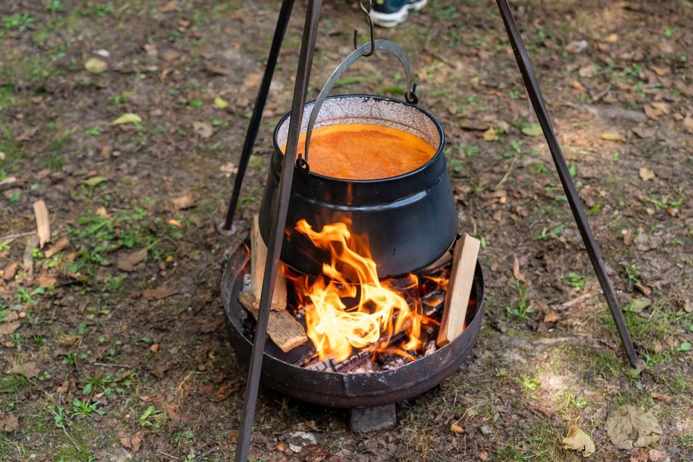 Menu 7 Potjie &mdash; a cast iron potjie simmering over an open fire